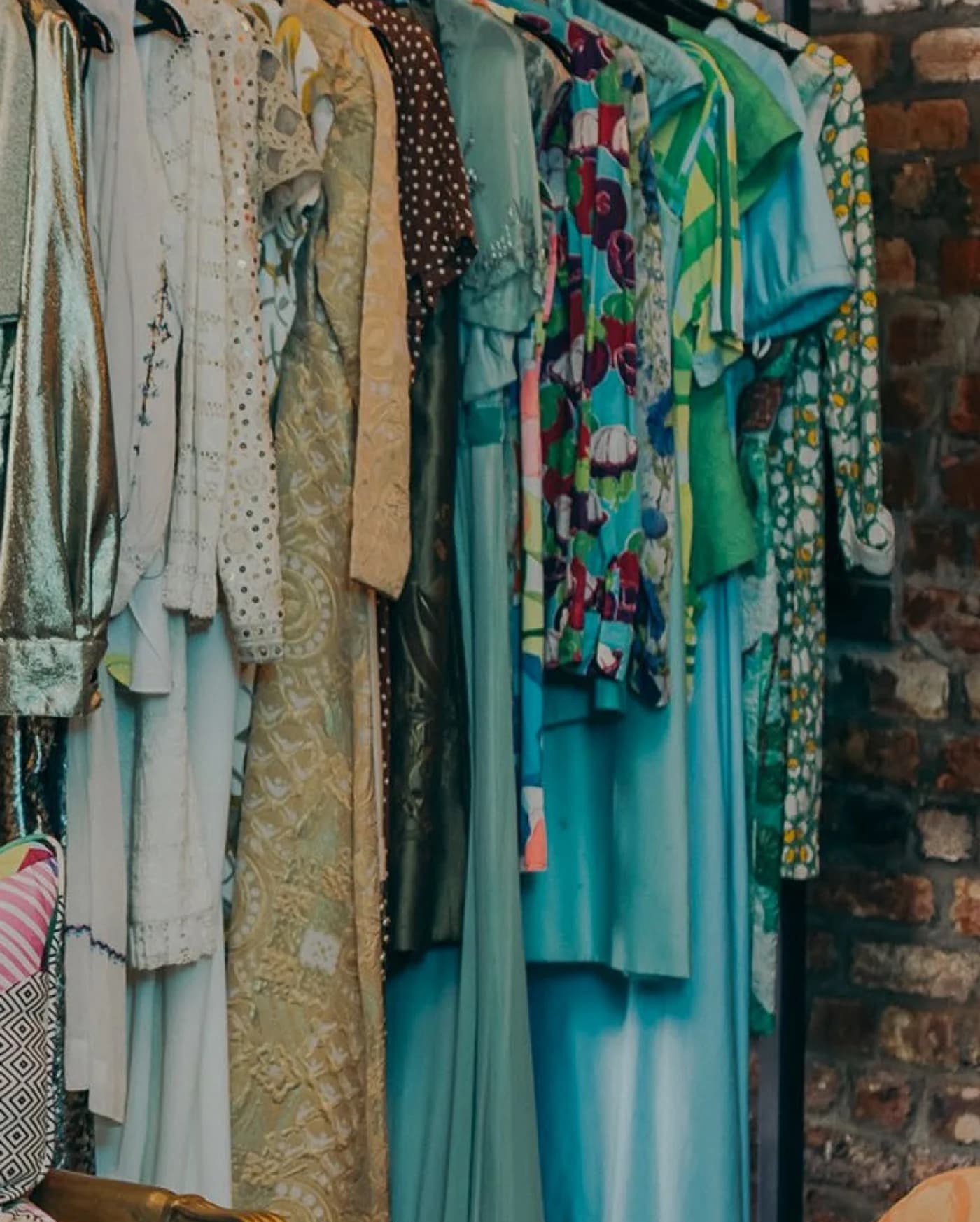 A corner of the shop — racks of dresses against a brick wall